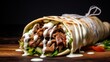 Beef shawarma sandwich fresh roll, wrap of grilled meat and salad tortilla wrap with white sauce. turkish Doner Kebab on a lavash - Shawarma Beef.