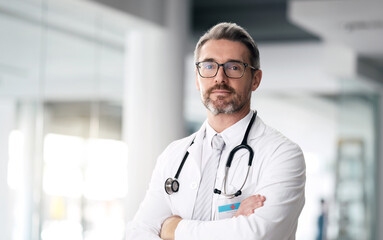 Poster - Serious doctor, portrait and man with arms crossed in hospital for healthcare, wellness or career. Face, medical professional and confident surgeon, expert and mature employee in glasses in Canada