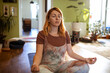 © Marko Geber - Young Caucasian woman doing yoga inside her home