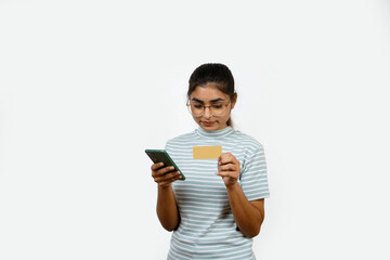 Beautiful young blonde woman holding up a credit card while avoiding her eyes from the copy space in the picture pose.