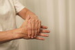 © kiattisak - A woman uses her other hand to feel pain and tingling. along with Guillain-Barre syndrome and numbness in the hands Elderly woman tries to massage herself to relieve wrist pain