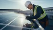 © Oulaphone - Male engineer worker examining or installing solar panels system outdoors