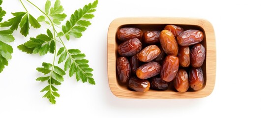 Poster - Pattern of dates with leaves in a wooden bowl isolated on a white background with copyspace for text