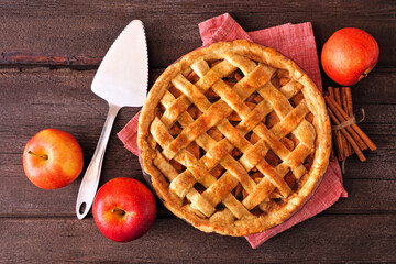 Poster - Homemade autumn apple pie. Top down view table scene over a dark wood background.