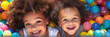 banner Portrait two Happy laughing children having fun in ball pit on birthday party in kids amusement park and indoor play center, playing with colorful balls in playground ball pool.