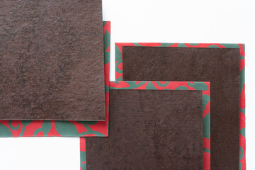 Canvas Print - brown paper pieces on top of red paper with green pattern