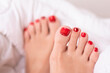 
Beautiful female feet with pedicure nails, red gel polish, glitter design