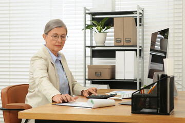 Sticker - Senior accountant working at wooden desk in office