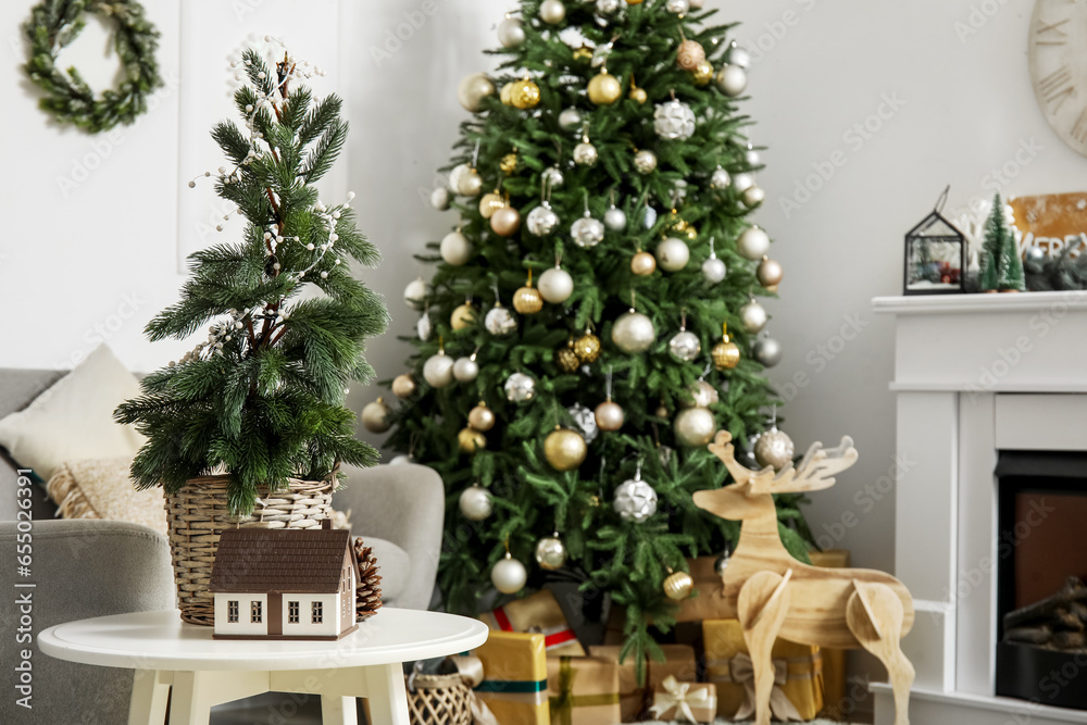 Small fir tree on table in living room with Christmas tree, closeup