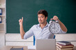 Young male teacher in time management concept