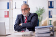 © Elnur - Old male employee and too much work in the office