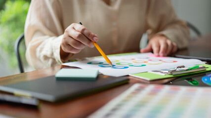 Poster - creative graphic designer looking on color swatch and choosing color to designing project in office