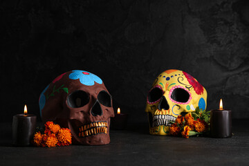 Marigold flowers with candles and painted skulls on black background. Celebration of Mexico's Day of the Dead (El Dia de Muertos)