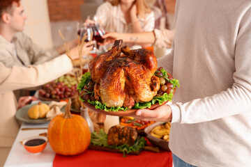 Sticker - Young man with turkey having dinner on Thanksgiving Day, closeup