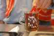 stirring Traditional turkish tea on white table .
