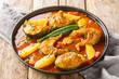 Machher jhol or machha jhola, is a traditional spicy fish curry in Bengali and Odia cuisines closeup on the plate on the wooden table. Horizontal