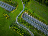Fototapeta Miasta - Aerial view of a green bridge ecoduct for fauna crossing above the highway.