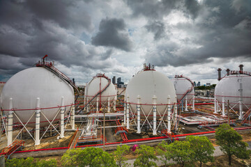 Wall Mural - White spherical propane tanks containing fuel gas storm cloud