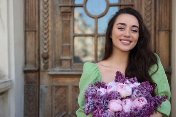 Poster - Beautiful woman with bouquet of spring flowers near building outdoors, space for text