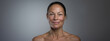 Close up portrait of happy and confident mature middle aged woman bare face with no makeup and aging skin with wrinkles, positive self image, hair pulled back