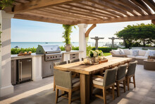 A Coastal Outdoor Kitchen Featuring A White Pergola, A Built-in Grill With A Reclaimed Wood Surround, And A Dining Area With A Driftwood Table And Slipcovered Chairs