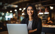 Portrait of young Indian smiling businesswoman using laptop in office, strong women concept