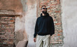 © San4ezz007 - Urban Portrait of Handsome Hipster Man with a Beard Wearing a Black Blank Hoodie with Space for your Logo or Design. Unique Mockup for Print