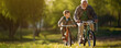 Happy grandfather teach cycling a child in park, wide banner