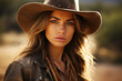 Young cowgirl woman in cowboy hat looking confidently at camera