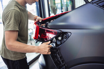 Wall Mural - Replacing spare parts on a disassembled car in a car service garage