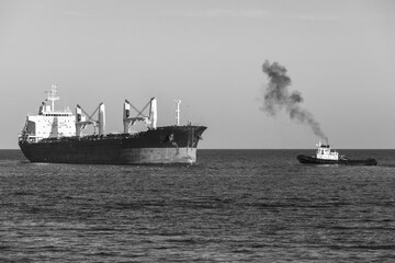 Wall Mural - Bulk carrier and tug boat sail the Black Sea. Varna harbor