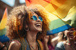 Woman with curly hair proudly holds vibrant rainbow flag, symbolizing support and solidarity for LGBTQ community. Diversity, equality, and inclusivity in various contexts