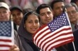 Group of  immigrants holding a small US flag the day of her naturalization