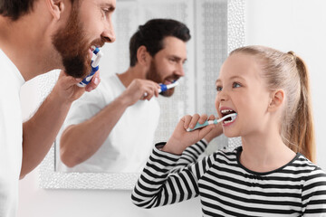 Wall Mural - Father and his daughter brushing teeth together in bathroom