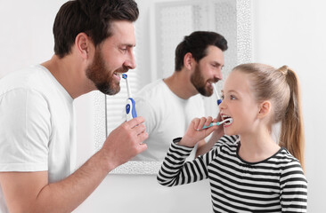 Wall Mural - Father and his daughter brushing teeth together in bathroom