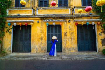 Vietnamese girls in national costumes Walk and lead an ancient bicycle. Play the old town of Hoi An, Vietnam. with a beautiful and unique architecture.