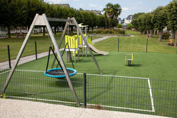 Wall Mural - Colorful wooden slide and swing playground on yard in city park