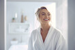 © toonsteb - a beautiful woman smiling in the bathroom wearing white robe