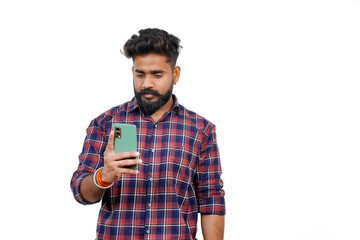 Young man in casual attire taking a selfie and uploading it to social media, isolated against a plain, pastel light white background.