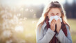 Woman sneezing into a paper tissue. Concept of allergies, colds and getting sick. Shallow field of view with copy space.