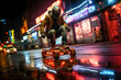 A man rides a futuristic hoverboard through a neon-lit cityscape at night.
