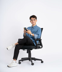 Wall Mural - Full body of young Asian man using phone on white background