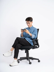 Wall Mural - Full body of young Asian man using phone on white background