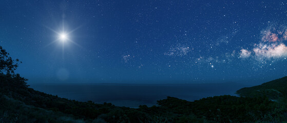 christmas star shines at night over the mountains of bethlehem