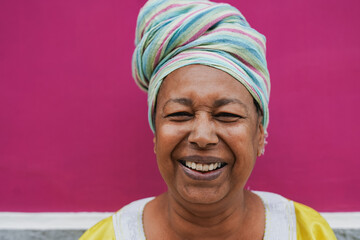 Wall Mural - Happy african senior woman wearing traditional dress and turban while smiling in front of camera