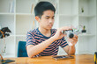 © photobyphotoboy - Asian boy learning and studying the work of technology robots.homeschool and science for tech project. playing childhood kids hobby leisure lifestyle people toys robotics technology.