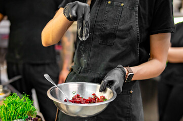 Wall Mural - professional chef's hands cooking Raw beef meat tartar in restaurant kitchen