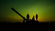 Silhouette Group Of Special Forces Sodiers Standing And Sit On Tank Gun Truck With Over The Sunset And Green Colorful Background Process,