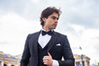 © Alex Vog - Portrait of confident stylish man in tuxedo and bow tie posing at cloudy sky, strong looking away. Pensive fashionable young guy businessman in tux, luxury image cinematic style. Copy ad text space