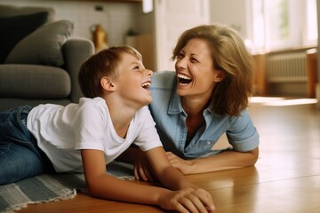 Wall Mural - Mother and son having fun lying on the floor at home